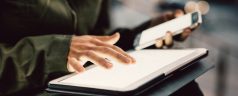 Close up on hands of woman using smartphone and tablet